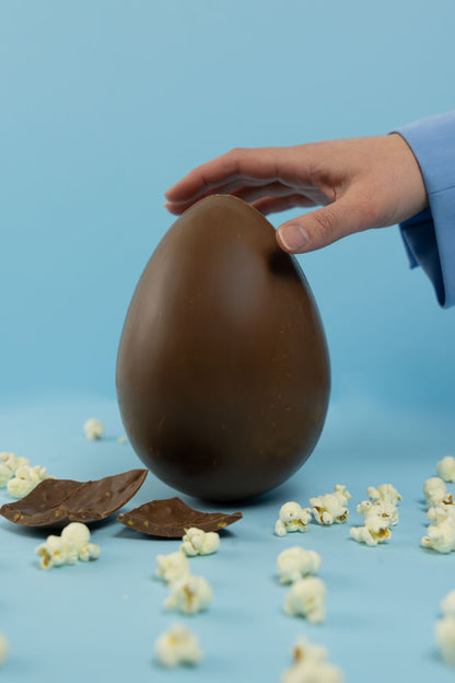 Uovo di cioccolato al latte pop corn, caramello e sale